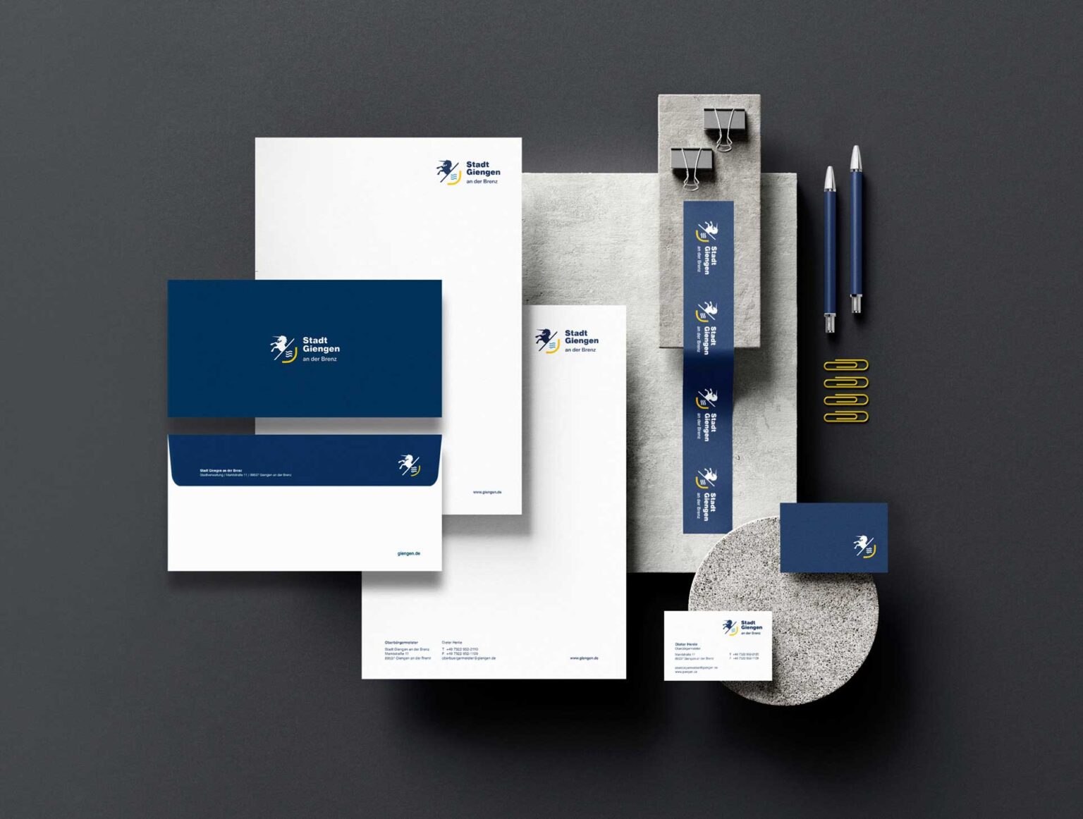 Mockup von Büromaterialien, gestaltet mit dem Markenbild der Stadt Giengen. Auf dem Bild sind Papier, Umschläge und Visitenkarten zu sehen