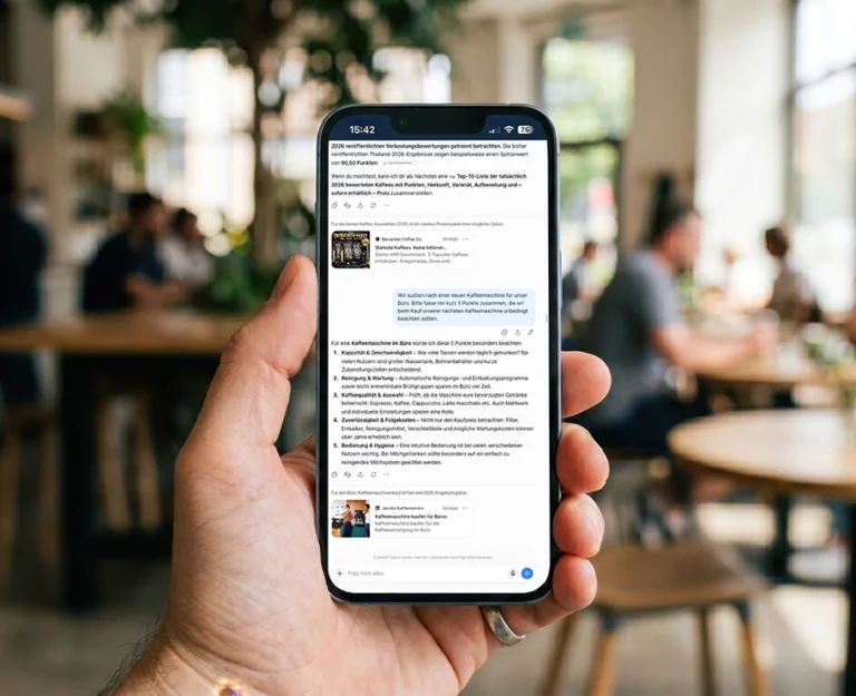 Eine Person hält in einem hellen, modernen Café ein Smartphone in der Hand, auf dessen Bildschirm eine Messaging-App zu sehen ist; im Hintergrund sitzen verschwommene Menschen an Tischen, was die Atmosphäre einer dynamischen Social-Media-Kampagne perfekt einfängt.